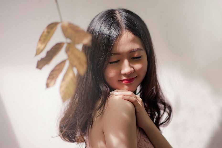 Peaceful young woman with eyes closed, embracing serenity with a gentle smile.